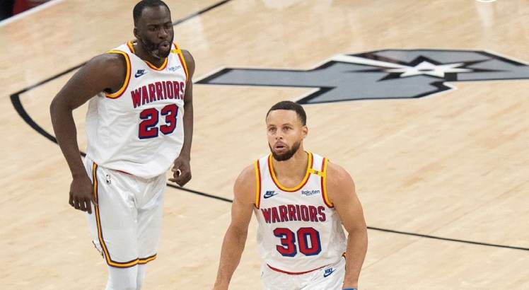 Jogadores LeBron James e Stephen Curry em ação pelo Warriors em partida da NBA.